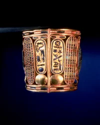Náramek s kartuší Psusennes I (asi 1039-991 př.nl) nalezený na pažích krále Amenemope v Tanis, třetí přechodné období (zlato vykládané polodrahokamy)